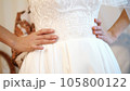 bride fees. the bride is dressed for the wedding. close-up of the bride's hands with a gentle manicure, against the background of a white lace dress . Wedding dress details, close up. 105800122