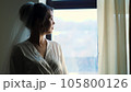 portrait of a bride, beautiful girl, in veil and white peignoir, robe, looks out the window 105800126
