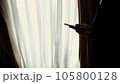 at dusk, in the darkness, opposite the window. handsome man, businessman in a white shirt and blue jacket is holding a smartphone, talking on mobile phone, at home, in his bedroom 105800128