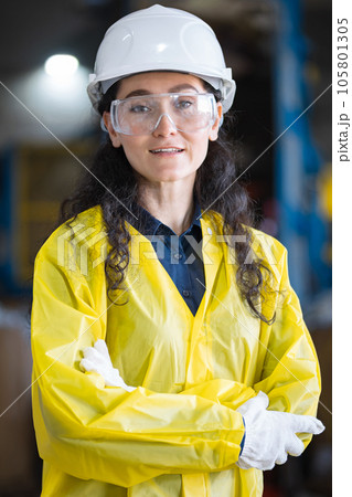 Female inspector in hardhat exploring waste sorting plant 105801305