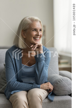 Happy pretty old mature woman relaxing on home couch Happy pretty old mature woman relaxing on home couch 105801489