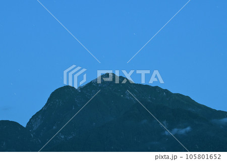 北杜市白州町、空が白み始める頃、星が流れ甲斐駒七丈小屋（画面中央部辺り）の明かりが灯る 105801652