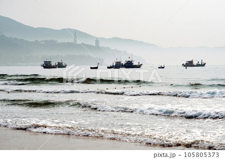 Boats floating near the beach in the brilliant dawn 105805373