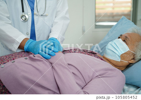 Doctor check Asian elder senior woman patient wearing a mask for protect covid coronavirus. 105805452