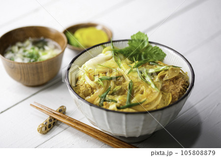 和食の定番！アツアツのかつ丼（カツ丼）お味噌汁と三つ葉を添えて 半熟卵（古板白背景） 105808879