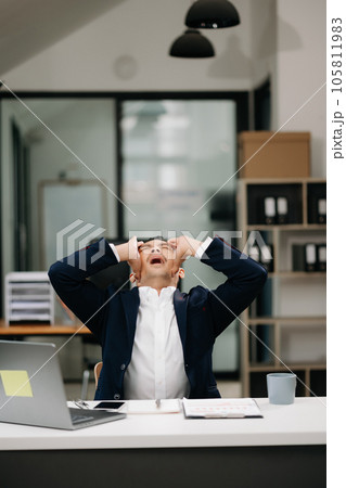 Overworked young Asian businessman office worker suffering from neck pain after had a long day at her office desk. office syndrome concept. 105811983