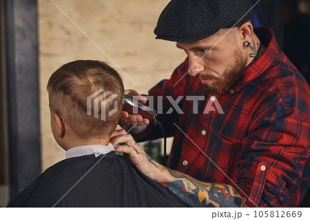 Caucasian boy getting haircut in barbershop indoor 105812669