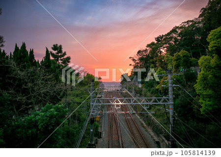 夕焼けに染まる電車と線路 105814139
