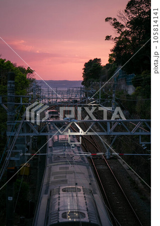夕焼けに染まる電車と線路 105814141