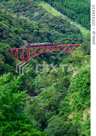 新緑の第一白川橋梁とトロッコ列車風景「全線開通・運航再開」(阿蘇長陽大橋周辺から撮影) 新緑の第一白川橋梁とトロッコ列車風景「全線開通・運航再開」(阿蘇長陽大橋周辺から撮影) 105816810