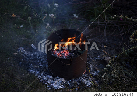 Burning garbage in the tank. Incineration of garbage in an iron bucket. Flames. Burning garbage in the tank. Incineration of garbage in an iron bucket. Flames. 105816844
