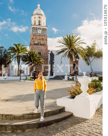 Smiling woman with the old architecture of city of Teguise in Lanzarote Smiling woman with the old architecture of city of Teguise in Lanzarote 105818670