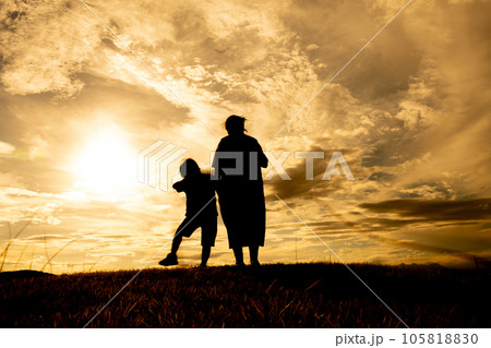 丘を散歩する母と息子 105818830