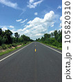 Image of new paved road in the daytime in the countryside painted yellow dividing line with trees, grass along the road, sky with white clouds 105820310
