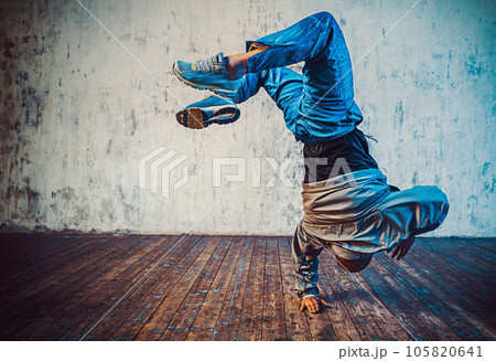 Young man break dancing on wall background Young man break dancing on wall background 105820641