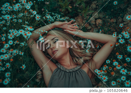 Young dreaming woman portrait on summer field with chamomiles Young dreaming woman portrait on summer field with chamomiles 105820646