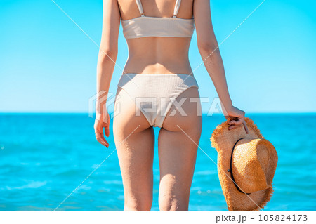 麦わら帽子を持つ水着姿の女性の後ろ姿 105824173