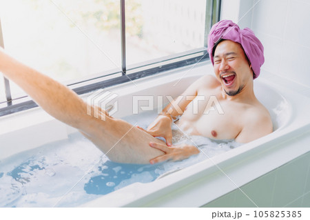 Funny asian man being childish and playful in a bathtub. Funny asian man being childish and playful in a bathtub. 105825385