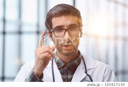 Head shot portrait male doctor talking online with patient, making video call, looking at camera 105827130