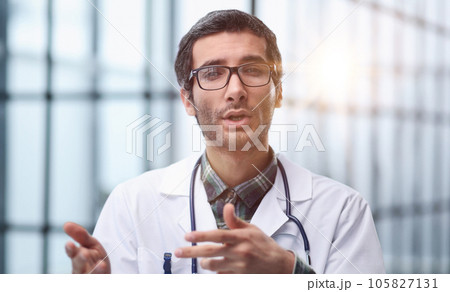 Head shot portrait male doctor talking online with patient, making video call, looking at camera 105827131