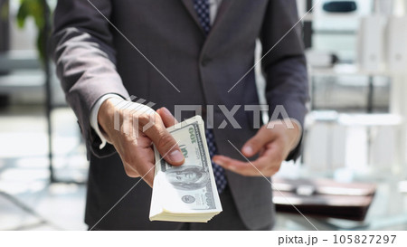 Business man handing you payment in cash banknotes 105827297