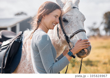 The bond between horse and rider. an attractive young woman standing with her horse on a ranch. 105828967