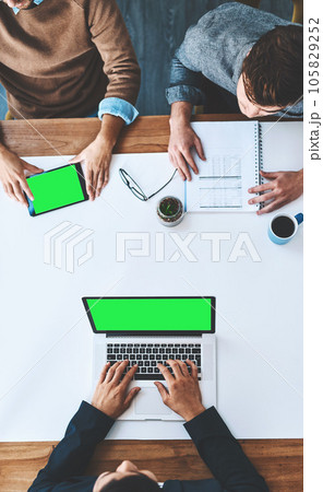 Green screen, copyspace and chromakey on the screen of a laptop and tablet in an office from above. Business people in a meeting, discussing marketing and advertising strategy in the boardroom Green screen, copyspace and chromakey on the screen of a laptop and tablet in an office from above. Business people in a meeting, discussing marketing and advertising strategy in the boardroom 105829252