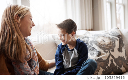 Family, children and love with a mother and son sitting on the sofa in the living room of their home together. Kids, relax and fun with a woman and boy child spending time or bonding in the house 105829416