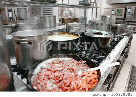 Food preparing in metal pots on the stove at professional kitchen 105829683