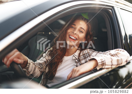 Young smiling woman driving a car in the city 105829882