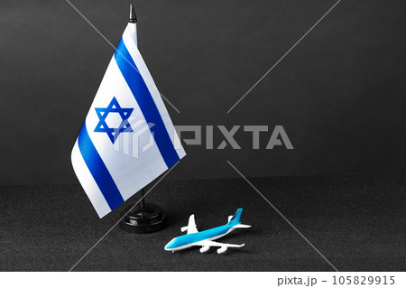 Small flag of Israel and toy plane on black background 105829915