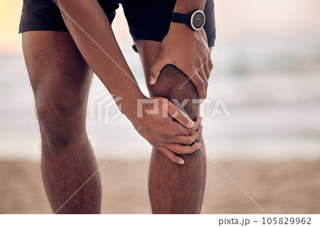 Knee injury, man hand and beach fitness with training, exercise and workout accident outdoor. Sea, ocean and male person holding leg from pain from run in nature with muscle strain and inflammation Knee injury, man hand and beach fitness with training, exercise and workout accident outdoor. Sea, ocean and male person holding leg from pain from run in nature with muscle strain and inflammation 105829962