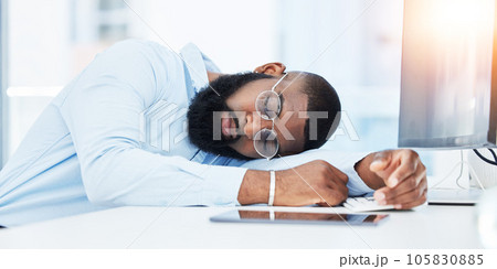 Sleeping, burnout and tired businessman in office overwhelmed by deadlines with fatigue at desk. Lazy worker, depressed consultant or exhausted black man resting or taking nap in overtime with stress 105830885