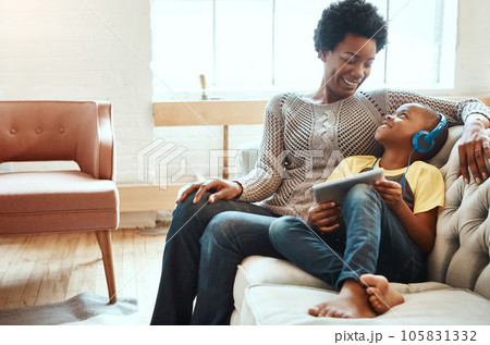 Tablet, relax and black family of kid, mom or African people relax together, bonding and enjoy quality time. Love, digital tech and youth child listening to music, streaming video or online gaming 105831332