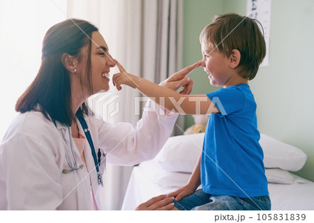 Woman doctor, playing and child at a hospital for healthcare and medical consultation. Fun, nose poke and pediatrician working with a laugh and happiness in a clinic with boy patient with exam 105831839