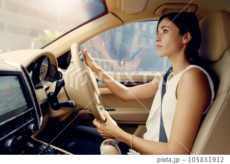 Woman, car and driver with a city road traveling to work and job. Young female person, driving journey and transportation travel in a vehicle on urban route in traffic downtown with transport Woman, car and driver with a city road traveling to work and job. Young female person, driving journey and transportation travel in a vehicle on urban route in traffic downtown with transport 105831912