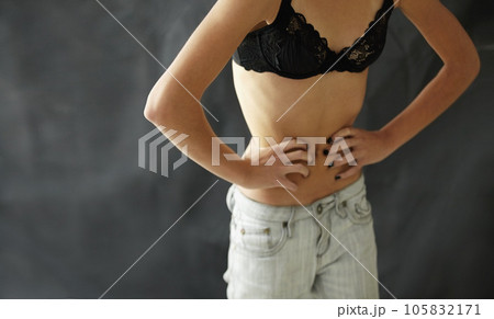 Anorexia, bulimia and stomach of woman in studio for weight, obsession and starvation on black background. Eating disorder, mental illness and girl waist suffering body dysmorphia, comparison or loss 105832171