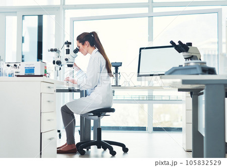 Paying close attention to detail. Cropped shot of a focused young female scientist looking through a microscope while doing tests inside of a laboratory. Paying close attention to detail. Cropped shot of a focused young female scientist looking through a microscope while doing tests inside of a laboratory. 105832529