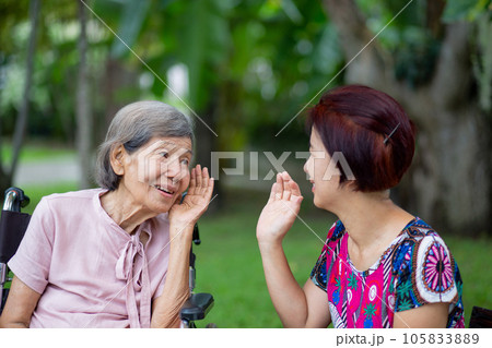 Asian seniors woman hearing loss , Hard of hearing try to talk with daughter. 105833889