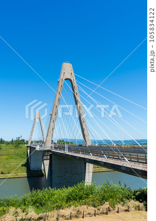 晴れの夏空と日本海と河北潟を繋ぐ河北潟放水路に架かる内灘大橋｜石川県河北郡内灘町 105834122