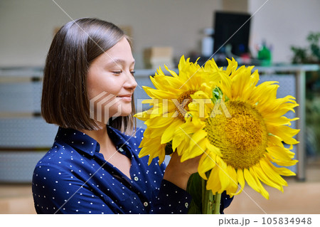 Young happy woman with bouquet of yellow sunflower 105834948