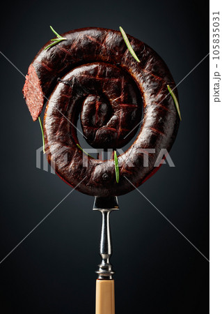 Spanish black pudding or blood sausage with rosemary on a fork. 105835031