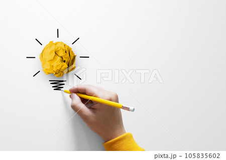 Paper scrap ball yellow colour with light bulb symbol 105835602