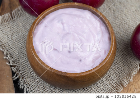 flavored pink yogurt with ripe and sweet plum flavored pink yogurt with ripe and sweet plum 105836428