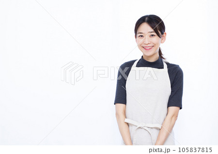 白い背景の前で笑顔で立つ30代主婦 105837815