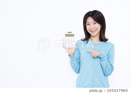 白い背景の前で電卓を指差す30代の女性 白い背景の前で電卓を指差す30代の女性 105837960