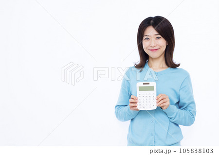白い背景の前で電卓を持つ30代の女性 白い背景の前で電卓を持つ30代の女性 105838103