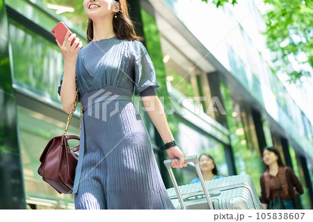 スーツケースを持って街を歩く女性 スーツケースを持って街を歩く女性 105838607
