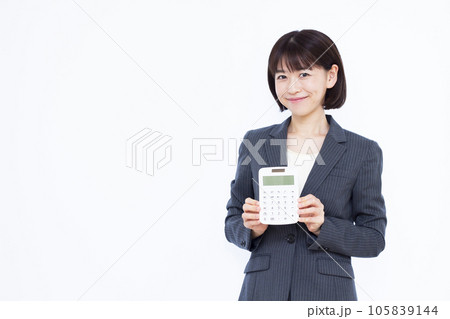 白い背景の前で電卓を持つ30代のビジネスウーマン 白い背景の前で電卓を持つ30代のビジネスウーマン 105839144