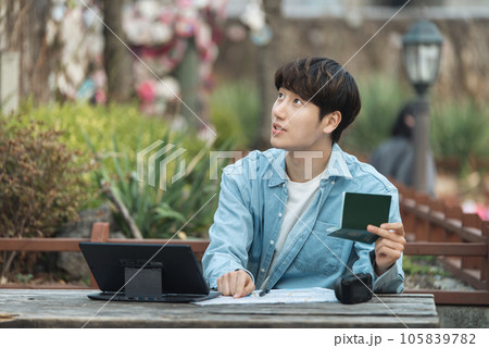 young man with laptop sitting on bench young man with laptop sitting on bench 105839782